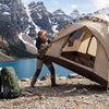 A camper quickly pitching an instant pop-up tent with the frame springing open