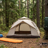 A well-organized efficient campsite with tent and gear neatly arranged at golden hour