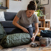 Camper checking backpack, tent and gear at home before a trip - preventive gear maintenance