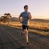 A runner on an empty morning road wearing a light breathable neck gaiter