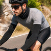 Finvizo UPF 50 arm sleeves and neck gaiter worn by a cyclist on a sunny road - forearm sleeve