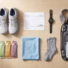 Marathon race-day gear flat lay with running shoes, race bib, GPS watch and cooling towel