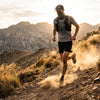A trail runner on a dusty mountain path with a neck gaiter pulled up over the face