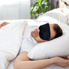 man sleeping in bed wearing black 3D contoured sleep mask