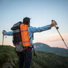 Solo hiker with backpack and trekking poles at sunset - quiet solo camping gear