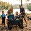 Finvizo family loading camping gear into collapsible wagon at sunny campsite