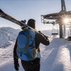 Finvizo 50L backpack opened by a skier organizing gear on a snowy mountain summit - ski trip packing beyond slopes