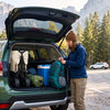 Loading folded camping gear and a wagon cart into an SUV trunk