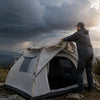 Camper pulling a rainfly over a Finvizo tent as storm clouds roll in - Yellowstone variable weather gear