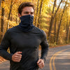 Runner wearing a Finvizo neck gaiter on a fall foliage road