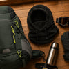 Ski trip flat-lay: Finvizo backpack, fleece balaclava, goggles and gloves on a cabin floor